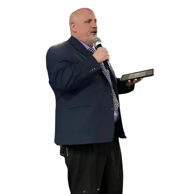 Aaron R. Shope speaking into a microphone while holding a tablet